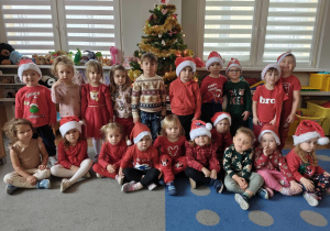 Dzieci pozują na tle ubranej choinki