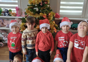 Dzieci pozują na tle ubranej choinki