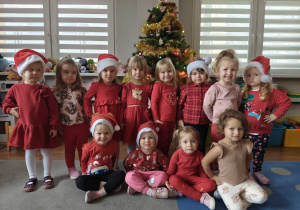 Dzieci pozują na tle ubranej choinki