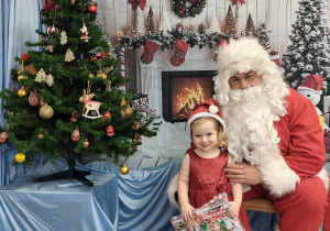 Gabrysia pozuje do zdjęcia ze Świętym Mikołajem