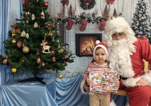 Kubuś pozuje do zdjęcia ze Świętym Mikołajem