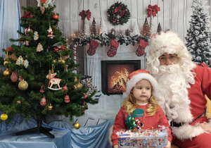 Michasia pozuje do zdjęcia ze Świętym Mikołajem