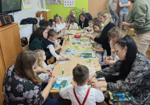 Rodzice z dziećmi wykonują świąteczne ozdoby