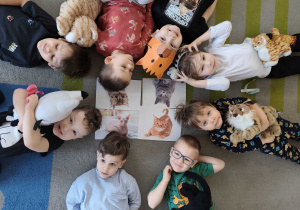 Dzieci pozują do zdjęcia ze swoimi maskotkami kotkami