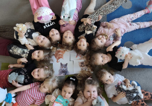 Dzieci pozują do zdjęcia ze swoimi maskotkami kotkami