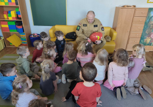 Strażak opowiada dzieciom o swojej pracy