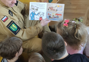 Strażak czyta dzieciom książeczkę