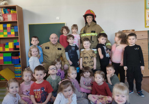 Dzieci pozują do zdjęcia ze strażakiem