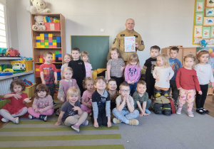 Dzieci pozują do zdjęcia ze strażakiem