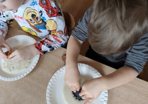 Dzieci robią odciski dinozaurów w masie solnej