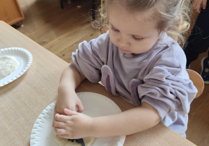 Dzieci robią odciski dinozaurów w masie solnej