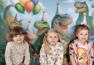 Dzieci pozują do zdjęcia na tle ścianki tematycznej