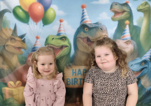 Dzieci pozują do zdjęcia na tle ścianki tematycznej