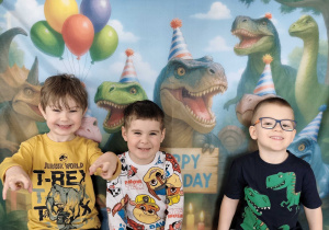 Dzieci pozują do zdjęcia na tle ścianki tematycznej