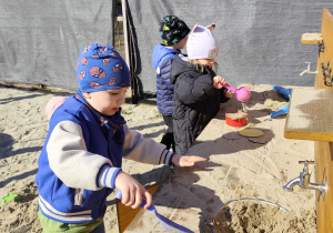Dzieci bawią się na przedszkolnym placu zabaw