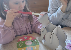 Dzieci z rodzicami robią wielkanocne ozdoby