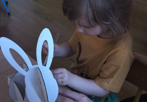 Dzieci z rodzicami robią wielkanocne ozdoby