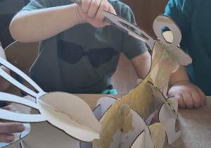 Dzieci z rodzicami robią wielkanocne ozdoby