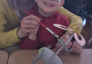 Dzieci z rodzicami robią wielkanocne ozdoby