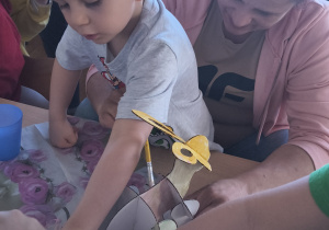 Dzieci z rodzicami robią wielkanocne ozdoby