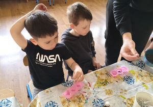 Dzieci czekają na wypełnienie foremek suszem