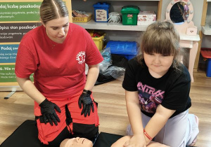 Karolina próbuje uciskać klatkę piersiową fantoma