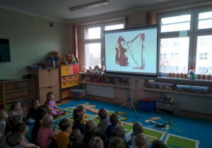 Dzieci oglądają na ekranie ilustracje związane z bajką