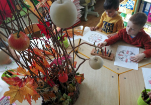 Chłopiec koloruje mandale z motywami drzew.