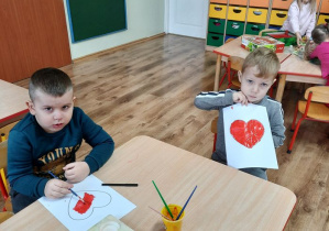 Kubuś zamalowuje serce, Adaś K. prezentuje swoją pracę - czerwone serduszko