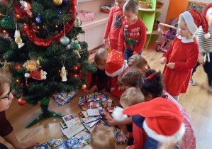 Dzieci oglądają prezenty leżące pod choinką