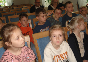 Dzieci siedzą na sali widowiskowej