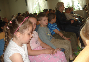 dzieci siedzą i słuchają koncertu w zamyśleniu