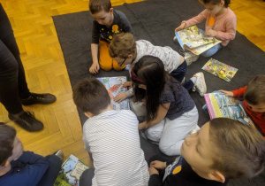 Dzieci oglądają książki o tematyce ekologicznej