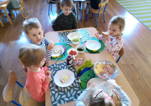 Dzieci z wielką ochotą zjadają przygotowane przez siebie kanapki