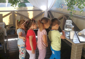 Dzieci samodzielnie nalewają sobie wodę.