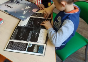 Maciek z Wojtkiem oglądają książki związane z tematyką kosmosu