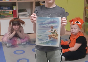 Leon prezentuje ilustrację do bajki O rybaku i złotej rybce.