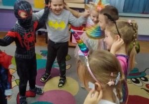 Dzieci trzymają się za uszy, tańcząc jeden z popularnych tańców dziecięcych