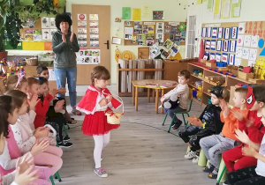 Dziewczynka prezentuje strój "Czerwonego kapturka" podczas pokazu strojów przygotowanych na tę okazję.