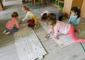 Dzieci kolorują szablon tekturowego "Domku z piernika".