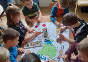 Promyczki kolorują obrazek przedstawiający dzieci z różnych stron świata.