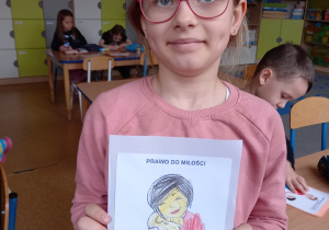 Nadia trzyma w ręku ilustrację przedstawiającą prawo dziecka do miłości