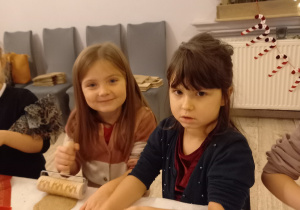 Lena i Maja wykrawają z ciasta kształty pierników