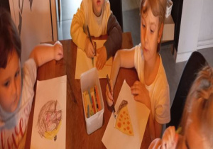 Dzieci wykonują rysunki na czapkę kucharską