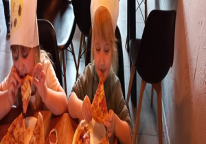 Weronika i Zosia ze smakiem zajadają pizzę