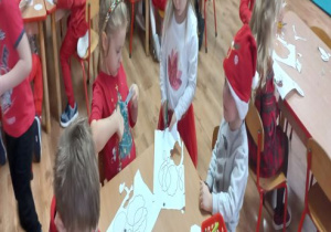 Dzieci wycinają elementy twarzy Mikołaja