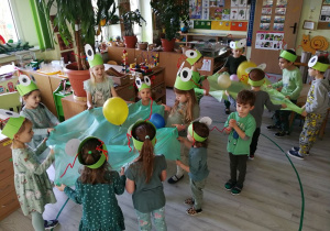 Dzieci bawią się w małych zespołach wykorzystując folię malarską i balony "Planety szaleją"
