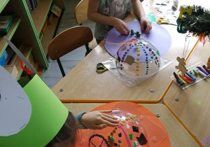 Dzieci konstruują statek kosmiczny z nieużytków i plasteliny.