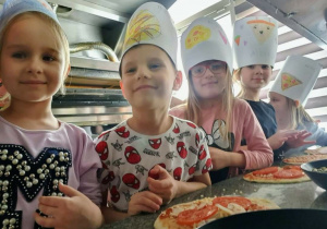 Dzieci samodzielnie przygotowują pizzę.
