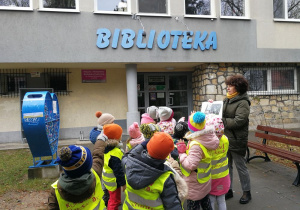 Dzieci stoją przed budynkiem Miejskiej i Powiatowej Biblioteki Publicznej